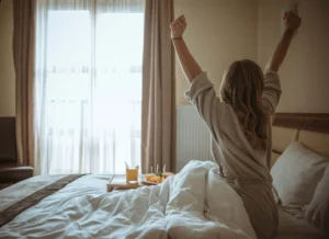 A woman on a bed with a breakfast tray in front of her